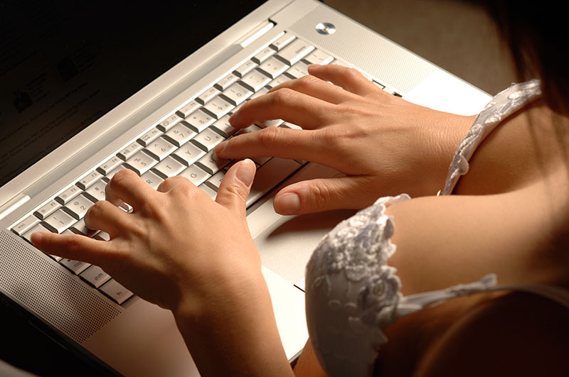 Frau im Dessous am Laptop schreibt im Sex-Chat