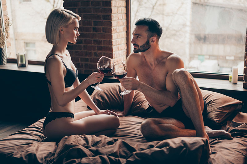 Mann und Frau bei Alkohol und Sex im Bett