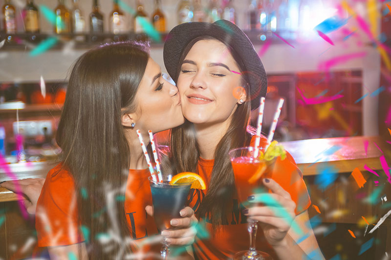 Frauen küssen sich auf Party
